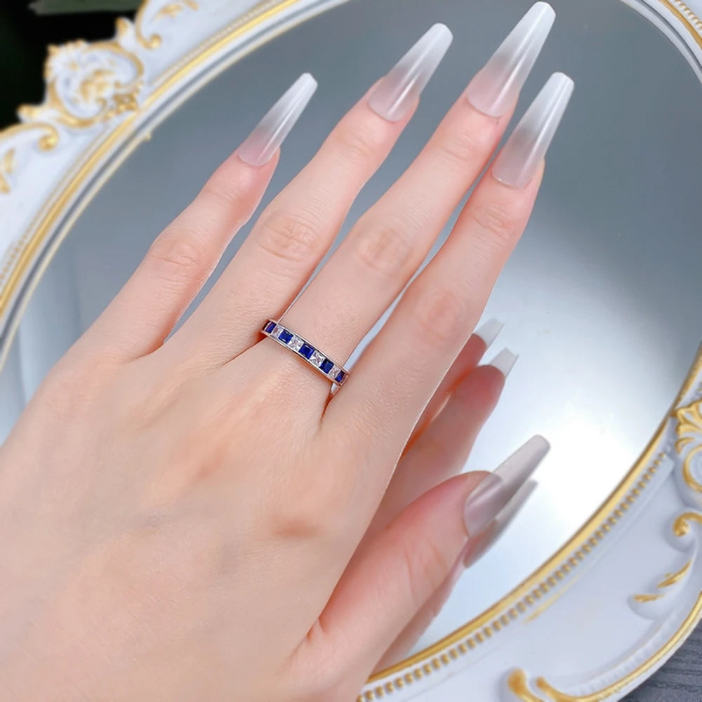 Jewelry 925 sterling silver eternity ring featuring sapphire main stones and 5A zircon high carbon diamond side stones in an elegant channel-set band design