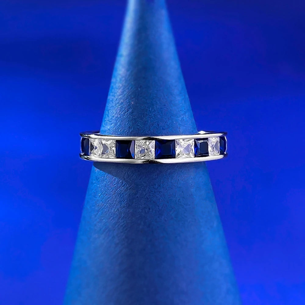 Jewelry 925 sterling silver eternity ring featuring sapphire main stones and 5A zircon high carbon diamond side stones in an elegant channel-set band design