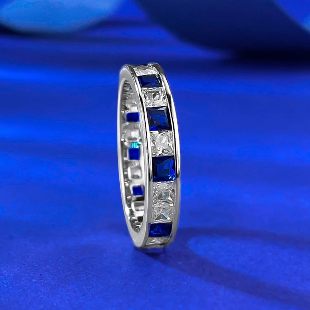 Jewelry 925 sterling silver eternity ring featuring sapphire main stones and 5A zircon high carbon diamond side stones in an elegant channel-set band design