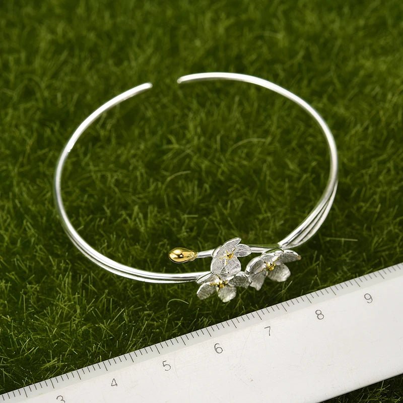 Handmade adjustable bangle for women in real 925 sterling silver featuring an elegant floral design with textured blossoms and an open cuff style.