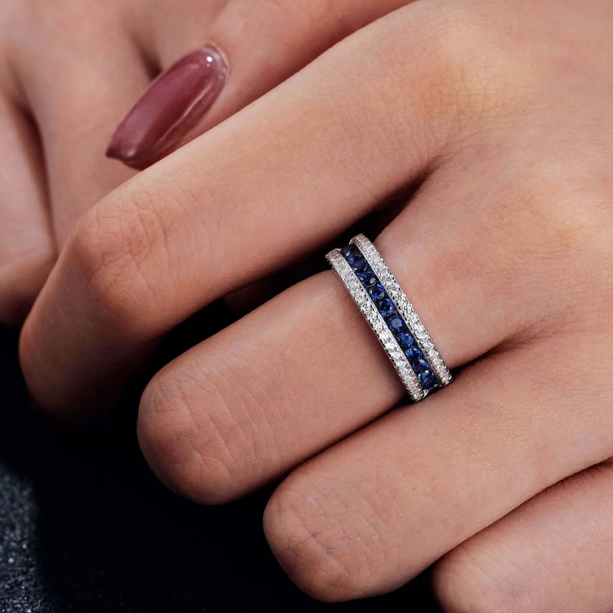 925 sterling silver jewelry ring with a white gold finish, featuring a row of sapphire-blue crystals bordered by sparkling clear stones in an elegant eternity band design.