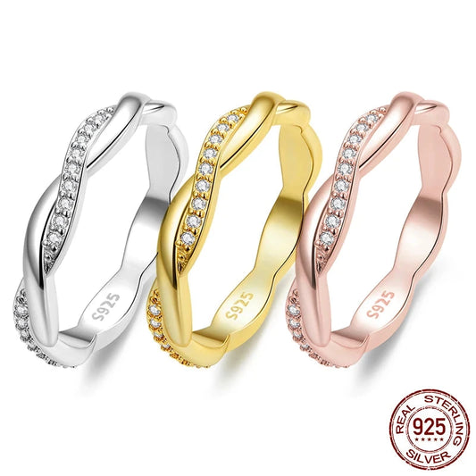 Three rings, one in silver, one in rose gold, and one in gold color, each with a central stone set in a ring.
