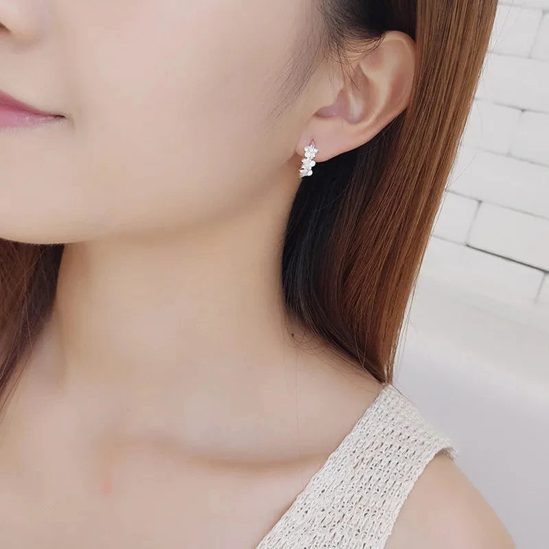Close-up of a woman wearing a silver earring with a blurred background
