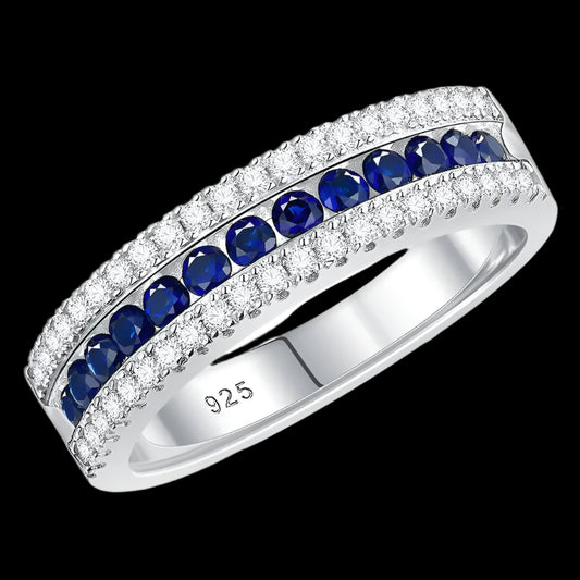 

925 sterling silver jewelry ring with a white gold finish, featuring a row of sapphire-blue crystals bordered by sparkling clear stones in an elegant eternity band design.


