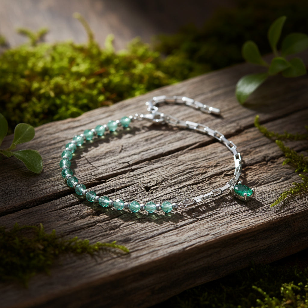 A sterling silver bracelet with green beads, featuring a clasp closure.
