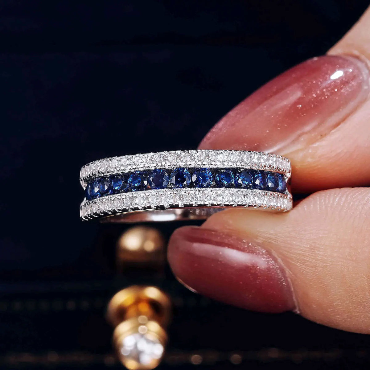 925 sterling silver jewelry ring with a white gold finish, featuring a row of sapphire-blue crystals bordered by sparkling clear stones in an elegant eternity band design.