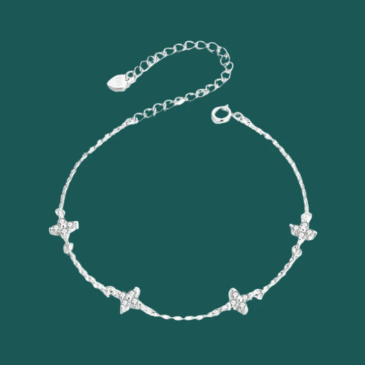 A sterling silver bracelet with white gold plating, featuring a chain design and adorned with small star-shaped charms.