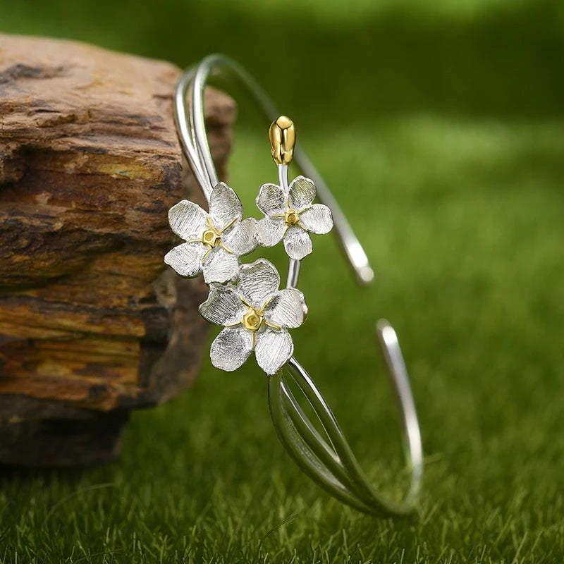 Handmade adjustable bangle for women in real 925 sterling silver featuring an elegant floral design with textured blossoms and an open cuff style.