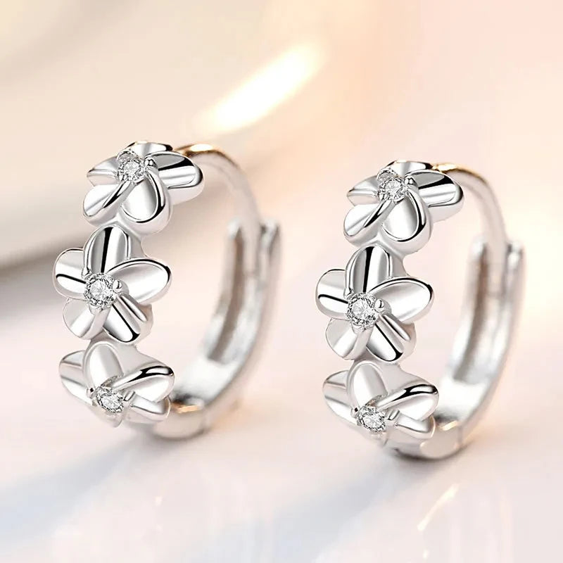 Silver earrings with floral design on a soft background