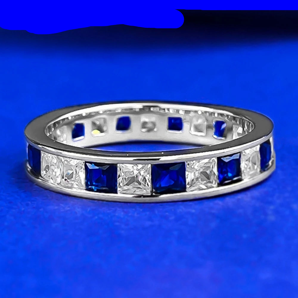 Jewelry 925 sterling silver eternity ring featuring sapphire main stones and 5A zircon high carbon diamond side stones in an elegant channel-set band design