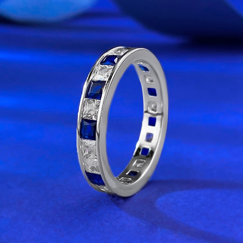 Jewelry 925 sterling silver eternity ring featuring sapphire main stones and 5A zircon high carbon diamond side stones in an elegant channel-set band design