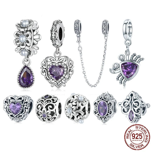 A collection of sterling silver charms with purple shining stones, various designs including heart-shaped and floral patterns.